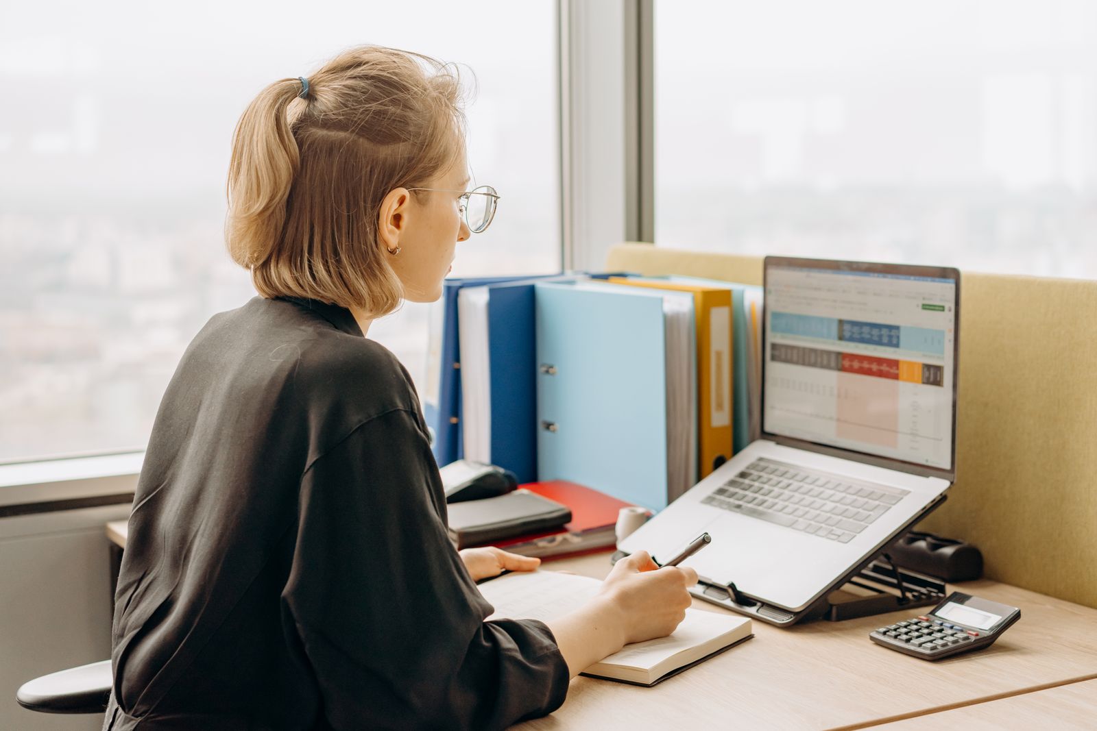 Business owner reviewing accounts on a laptop at an office desk