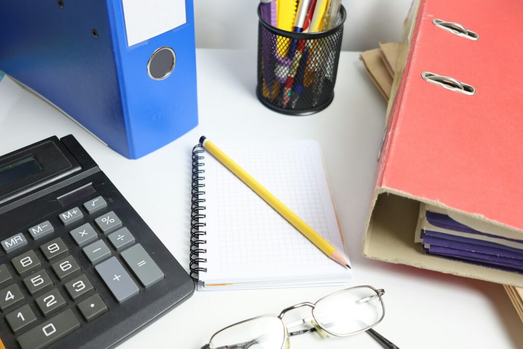 Desk with calculator, binders and notebook prepared for an accounting meeting
